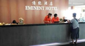 a group of people standing at a hotel counter at Eminent Hotel in Kampong Kabusik