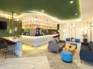 a lobby with a bar in the middle of a room at Novotel Suites Yogyakarta Malioboro in Yogyakarta
