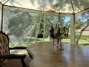a table in a tent with a view of a field at Le Fleur Sauvage in Chenay