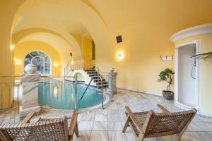 バードガシュタインにあるthe eighteen86 by keyoneの椅子と階段のある部屋にあるプール