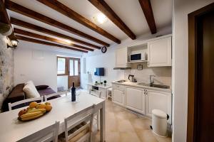 a kitchen with a counter with a bowl of fruit on it at Riva Suite 1 in Komiža +16 photos