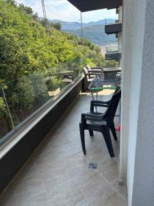 uma cadeira preta sentada numa varanda com vista em Apartment TACA em Kravlja