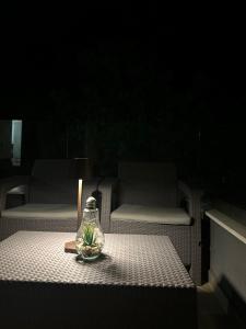 um frasco de vidro com uma vela sobre uma mesa com cadeiras em Apartment TACA em Kravlja mais 2 fotografias