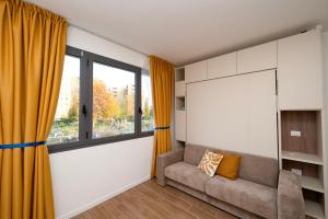 een woonkamer met een bank en een raam bij San Pier Tommaso Living in Bologna
