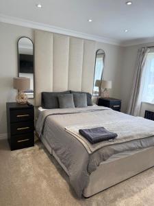 een slaapkamer met een groot bed en twee ramen bij 3 bedroom house Hildenborough in Hildenborough