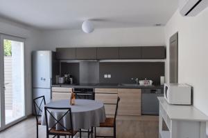 a kitchen with a table and a kitchen with a refrigerator at Appartements Les Pesquiers Hyères Plage in Hyères +14 photos