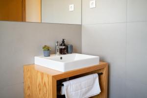 a bathroom with a white sink on a wooden stand at Oakstone Hills in Nelas +41 photos