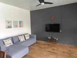 een woonkamer met een bank en een flatscreen-tv bij Villas Flora Bella Resort in Dauis