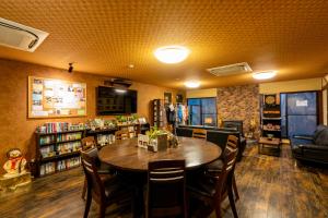 a library with a table and chairs and a book shelf at Guest House Ouka in Takayama