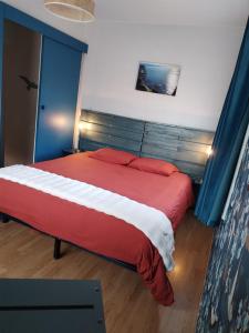 een slaapkamer met een rood bed met een blauw hoofdeinde bij Cajem in Étretat