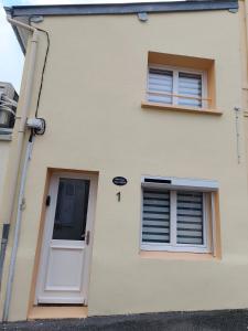 een wit huis met twee ramen en een deur bij Cajem in Étretat