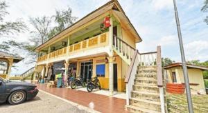 un edificio con un coche aparcado delante en OYO 90315 Chalet Pantai Rantau Panjang, en Kampong Kandang
