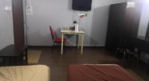 a room with a table and a red chair at OYO 90473 Opah Inn Hotel in Kampong Ayer Terjun +44 photos