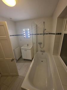 a bathroom with a tub and a shower and a sink at The Nook in Taunton