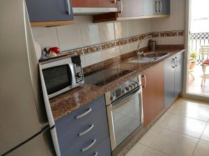 a kitchen with a microwave oven and a sink at Foz Playa y Mar by I Love Norte in Foz