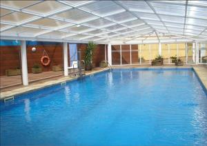 a large blue swimming pool with a ceiling at Foz Playa y Mar by I Love Norte in Foz
