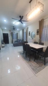 a dining room and living room with a table and chairs at REZEKI MUEZZA 3BR2B Cozy Homestay in Teluk Intan