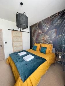 1 dormitorio con 1 cama grande con sábanas amarillas y azules en MAISON LE BEAULIEU, en Vichy
