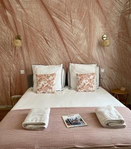 Una cama con dos toallas y una revista. en MAISON LE BEAULIEU, en Vichy