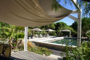 - une piscine avec des chaises et des parasols dans un complexe dans l'établissement Campagne les Jumeaux, à Saint-Tropez