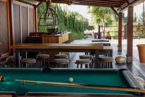 a pool table in front of a bar with stools at Hotel Boutique Canelobre in Busot