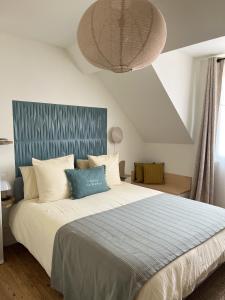 a bedroom with a large bed with a blue headboard at MAISON LE BEAULIEU in Vichy
