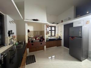 a large kitchen with a stainless steel refrigerator at Dream House Near IIM Kozhikode & NIT Calicut in Kozhikode