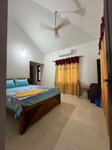 a bedroom with a bed and a ceiling fan at Dream House Near IIM Kozhikode & NIT Calicut in Kozhikode +20 photos
