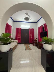 a living room with two potted plants in an archway at Dream House Near IIM Kozhikode & NIT Calicut in Kozhikode