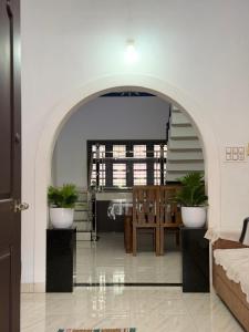 an archway in a living room with a table and chairs at Dream House Near IIM Kozhikode & NIT Calicut in Kozhikode