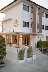 een wit gebouw met potplanten ervoor bij Morning Place in Ban Krathum Lom