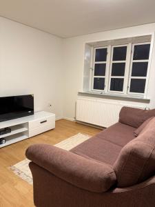een woonkamer met een bank en een flatscreen-tv bij Hobro Living House in Hobro
