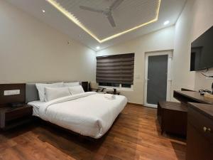 a bedroom with a large white bed with a ceiling at Muchaan Resort in Gochar
