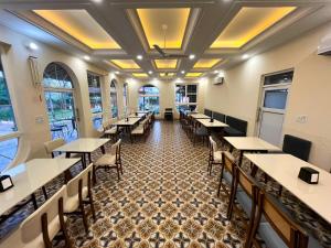 a dining room with tables and chairs and windows at Muchaan Resort in Gochar