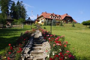 a stone path with flowers in front of a house at Hotel LOKIS in Niedzica Zamek