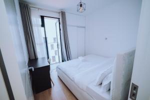 ein Schlafzimmer mit einem weißen Bett und einem Fenster in der Unterkunft Shan's Comfort Sanctuary in Tatu City