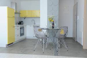 a kitchen with a glass table and two chairs at Apartment Livingstone in Rijeka