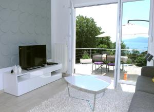 a living room with a tv and a couch and a table at Apartment Livingstone in Rijeka