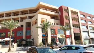 een gebouw met palmbomen ervoor bij Luxury Studio, pool, Private beach & close to Airport in Hurghada