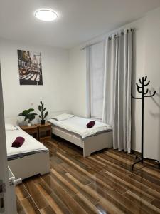 two beds in a room with wooden floors at Sweet Dream House in Brussels