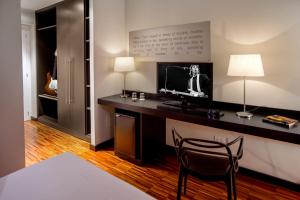 Cette chambre comprend un bureau avec une télévision et une chaise. dans l'établissement Suitedreams, à Rome