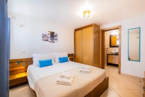 una camera da letto con un letto grande con asciugamani sopra di Margarida Apartment - Ping pong table a Vale de Pedras