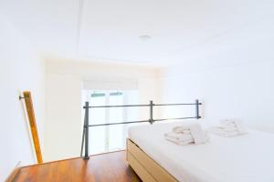 1 dormitorio con 1 cama con sábanas blancas y toallas en Elegantis Pompeo Magno Suite Apartment - Historic Center near the Vatican and Piazza del Popolo, en Roma