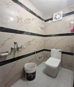 een badkamer met een toilet en een vuilnisbak bij Hotel Diamond Place in Jāmb