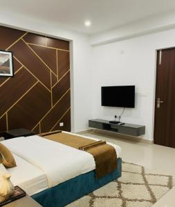 een slaapkamer met een groot bed en een flatscreen-tv bij Hotel Diamond Place in Jāmb