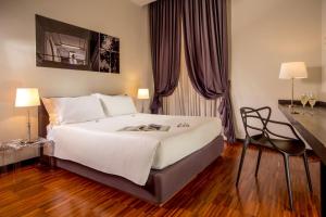 een slaapkamer met een groot wit bed en een bureau bij Suitedreams in Rome