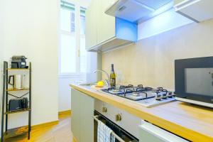 una cocina con estufa y fregadero en Elegantis Pompeo Magno Suite Apartment - Historic Center near the Vatican and Piazza del Popolo, en Roma