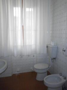 ein weißes Bad mit einem WC und einem Waschbecken in der Unterkunft Villetta di Campagna in Venturina Terme