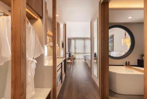a bathroom with a tub and a sink and a mirror at Na U Hotel in Chiang Mai