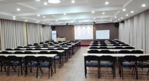a large room with tables and chairs and a screen at 7 Days Inn Qingdao Haier Zone Ditie Tower Jiushui West Road in Laoshan